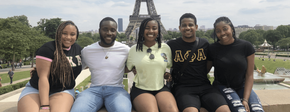 A group of students posing together in front of the Eiffel Tower